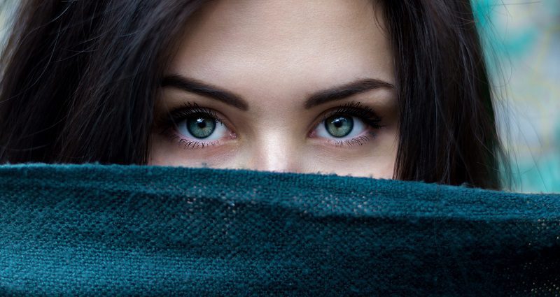 Dark Circles Under the Eyes at Home Remedies Woman Holding a Piece of Fabric Up in Front of the Lower Half of Her Face