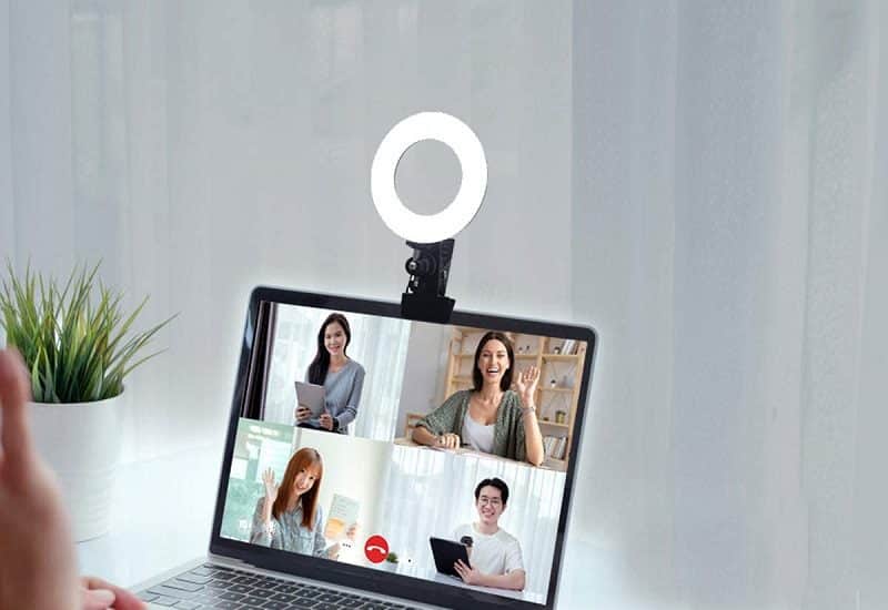 Video Conference Appearance Person Sitting at a Laptop with a Ring Light Attached to the Top for a Video Conference